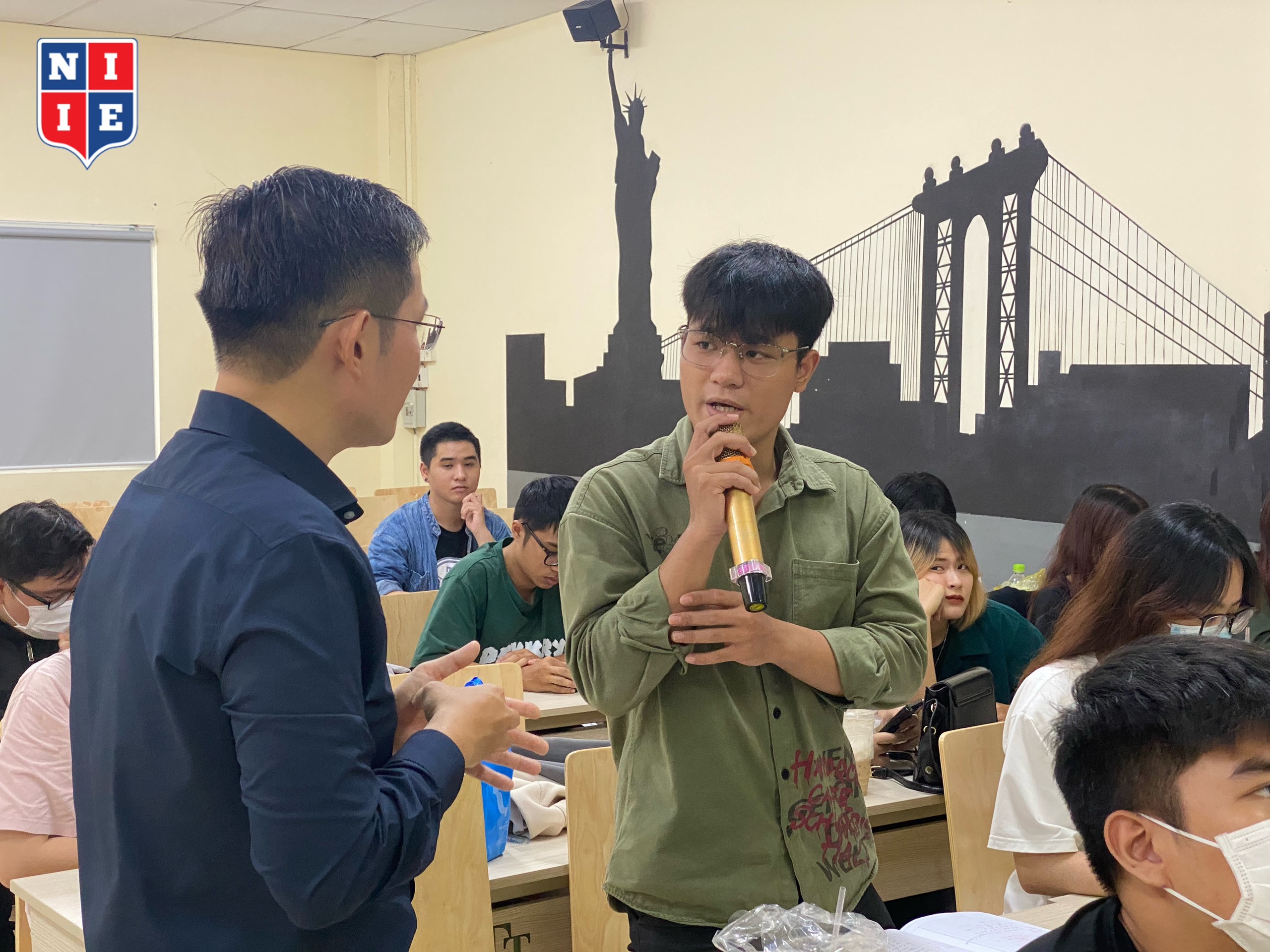 Students in course 2020 are actively asking questions to the speaker to understand the recruitment needs of businesses in their field of study.