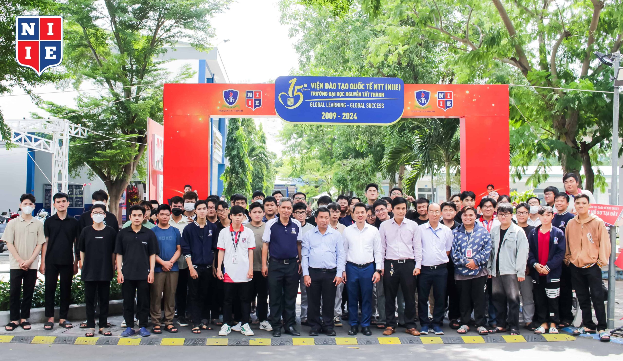 NIIE leadership and students take a commemorative photo with Assoc. Prof. Dr. Quan Thanh Tho at the 15th-anniversary gate of the Institute